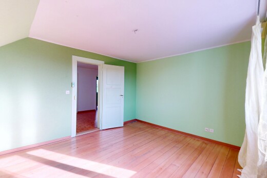 leerer raum mit gipskartonwand, sockelleisten, dachschräge, und holzfußboden