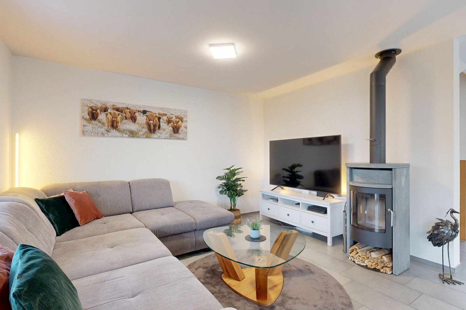 wohnzimmer mit fernseher, holzofen, inside property, gipskartonwand, und drywall