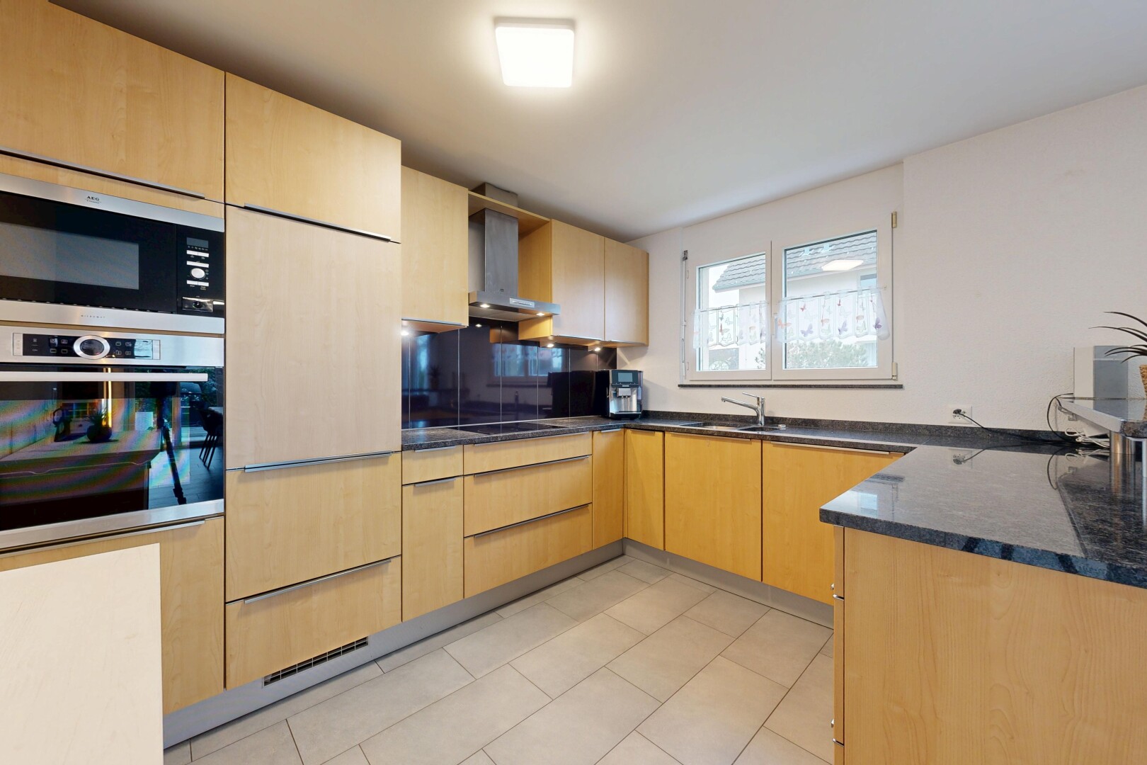 küche mit hellbraune schränke, light brown cabinets, ofen, dark countertops, und dunstabzugshaube
