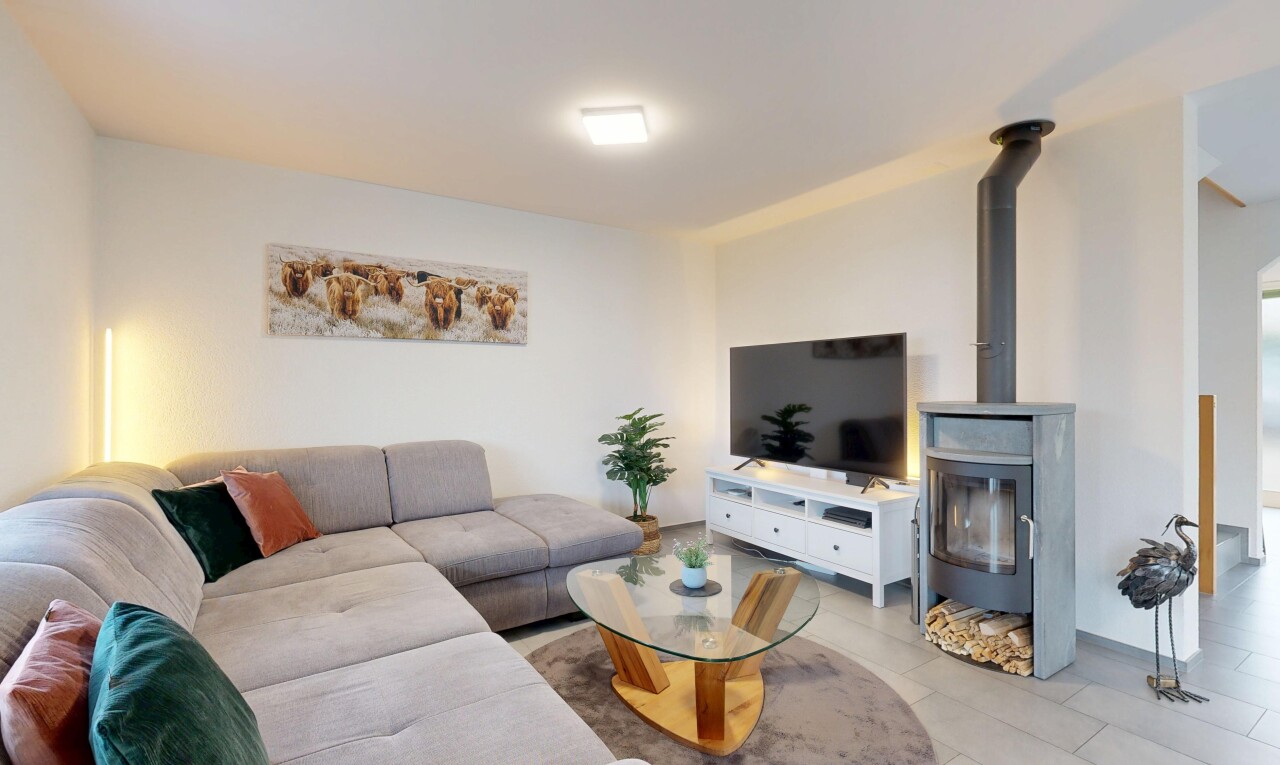 wohnzimmer mit fernseher, holzofen, inside property, gipskartonwand, und drywall