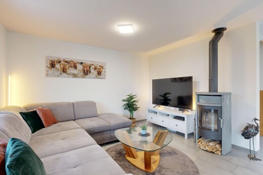 wohnzimmer mit fernseher, holzofen, inside property, gipskartonwand, und drywall