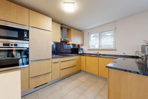 küche mit hellbraune schränke, light brown cabinets, ofen, dark countertops, und dunstabzugshaube