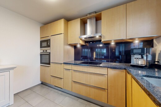 küche mit light brown cabinets, hellbraune schränke, stone countertops, stein arbeitsplatten, und dunstabzugshaube