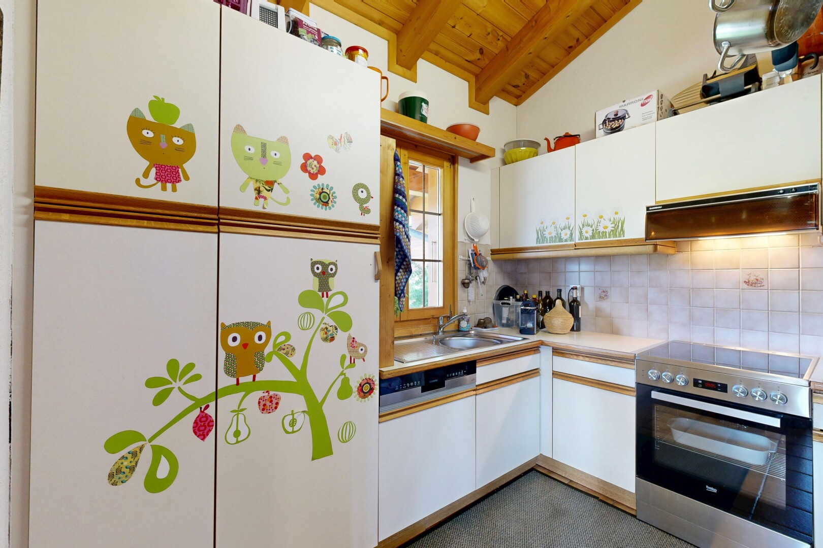 dual tone kitchen with electric stove, light countertops, wooden ceiling, backsplash, and lofted ceiling with beams