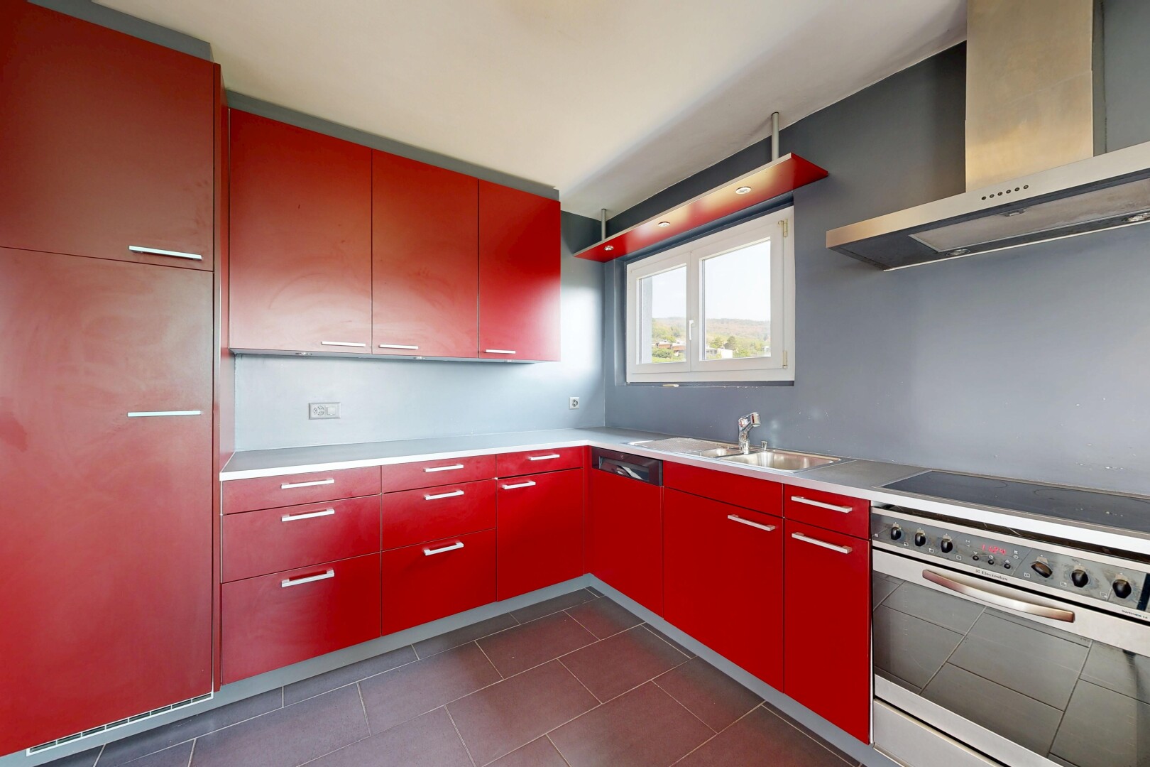 cuisine avec hotte, dark floor, four, évier, et plaque de cuisson