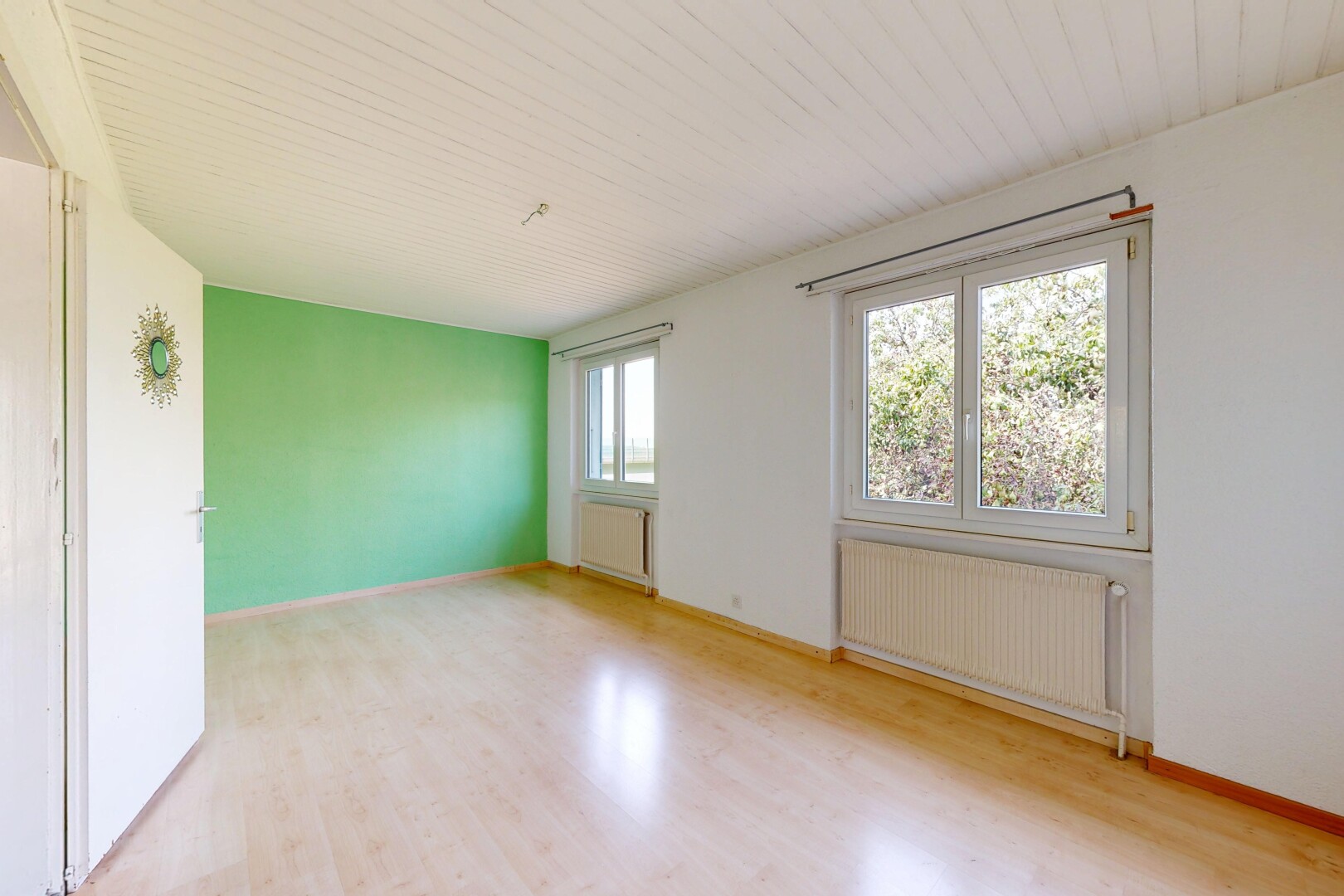 pièce vide avec sol en finition bois, wood finish floor, radiateur, cloison sèche, et drywall