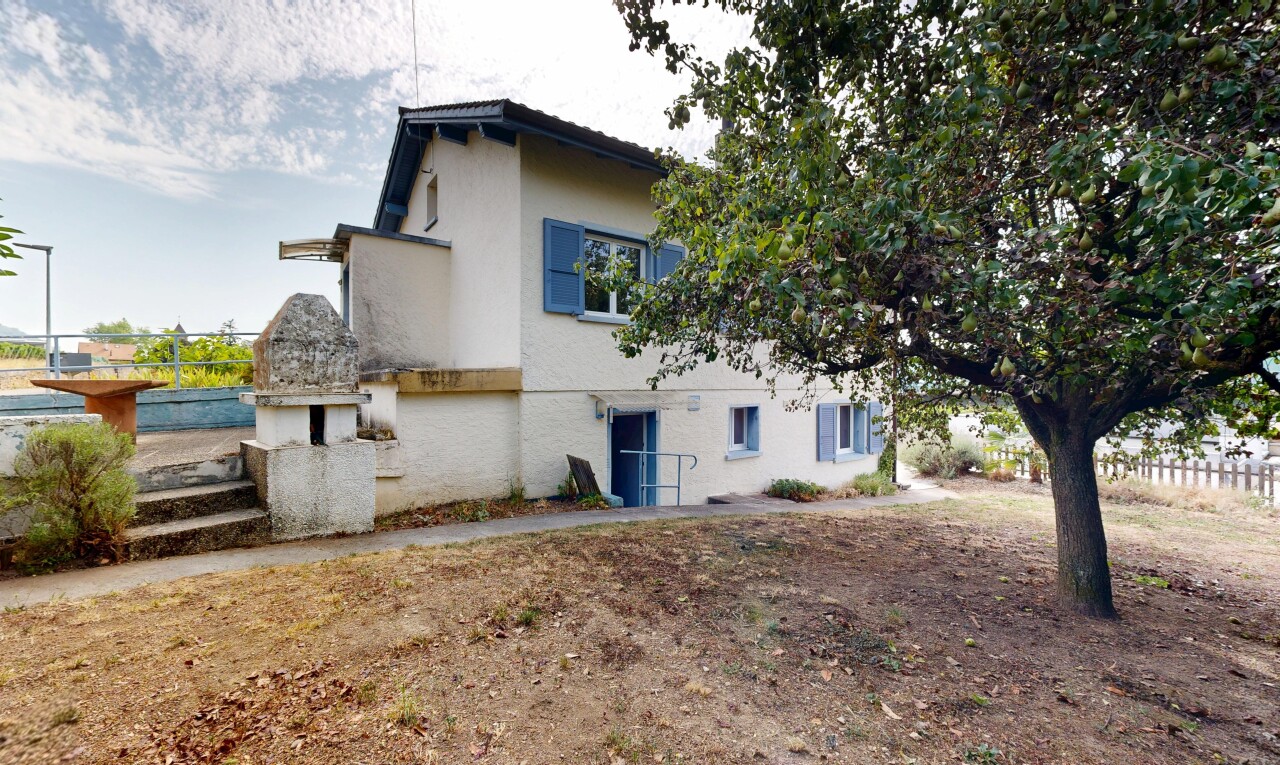 façade avec property visible, bardage en stuc, et clôture