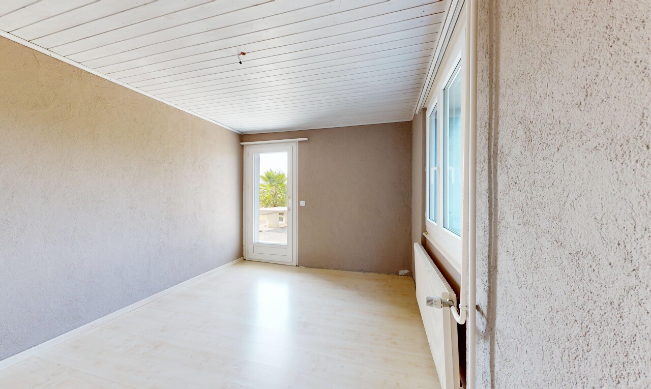 pièce vide avec mur texturé, textured wall, radiateur, sol en finition bois, et wood finish floor