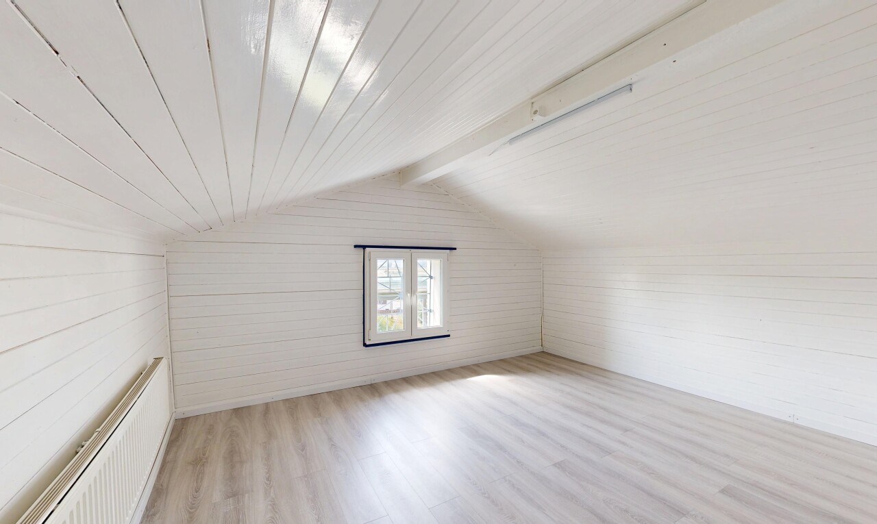 pièce vide avec wood finish floor, sol en finition bois, pièce supplémentaire, vaulted ceiling, et plafond voûté