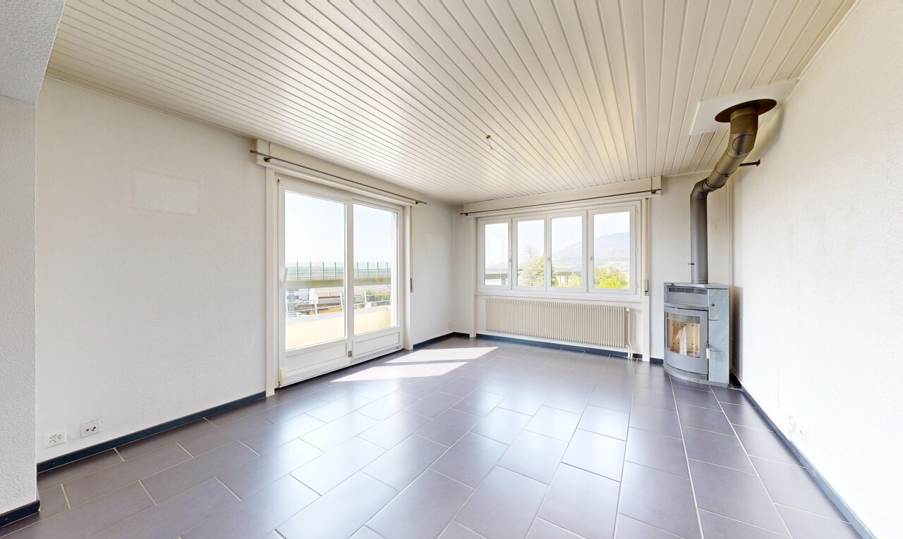 pièce vide avec poêle à bois, radiateur, cloison sèche, drywall, et plafond en bois