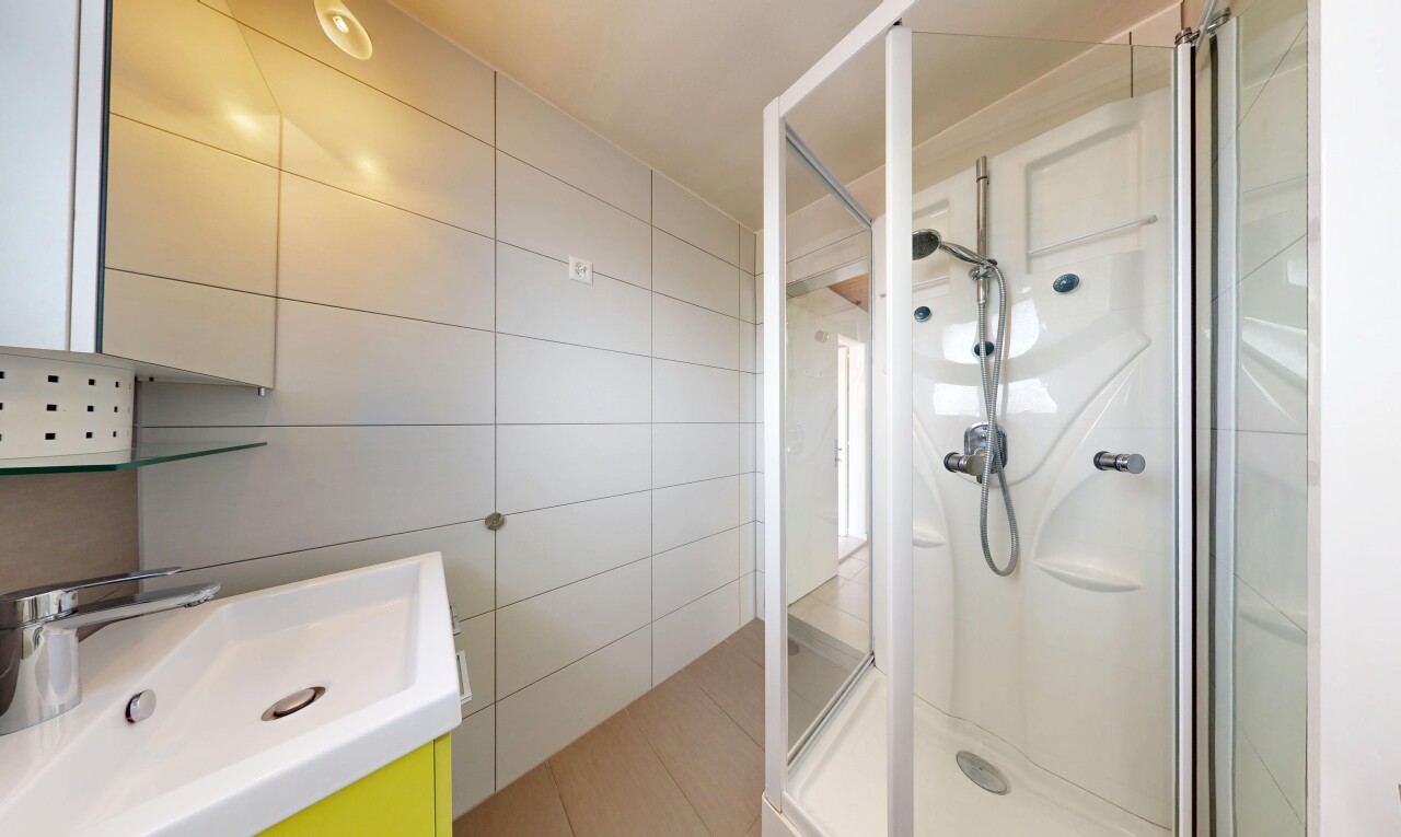 salle de bains avec mur en carrelage, tile wall, douche, salle de bain complète, et évier