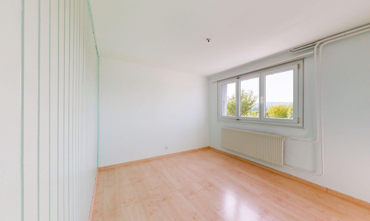 pièce vide avec wood finish floor, sol en finition bois, radiateur, drywall, et cloison sèche