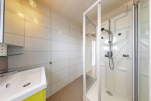 salle de bains avec mur en carrelage, tile wall, douche, salle de bain complète, et évier