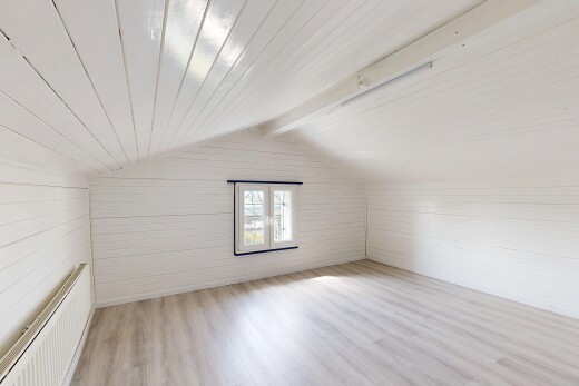 pièce vide avec wood finish floor, sol en finition bois, pièce supplémentaire, vaulted ceiling, et plafond voûté