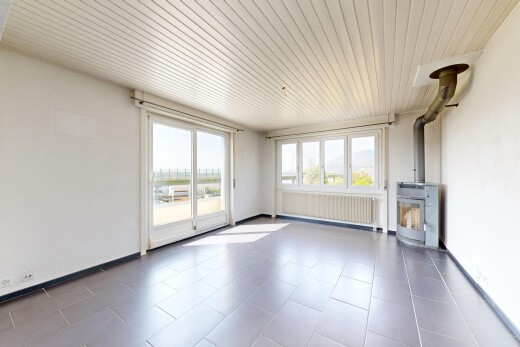 pièce vide avec poêle à bois, radiateur, cloison sèche, drywall, et plafond en bois