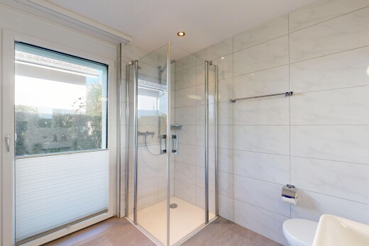 bathroom with tile walls, a shower stall, and recessed lighting