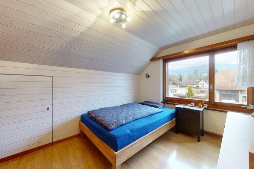zimmer / schlafzimmer mit zusätzliches zimmer, holzwand, wood wall, dachschräge, und vaulted ceiling