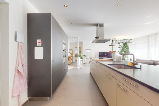 küche mit belüftungshaube, weißer schränke und hellen fliesenböden