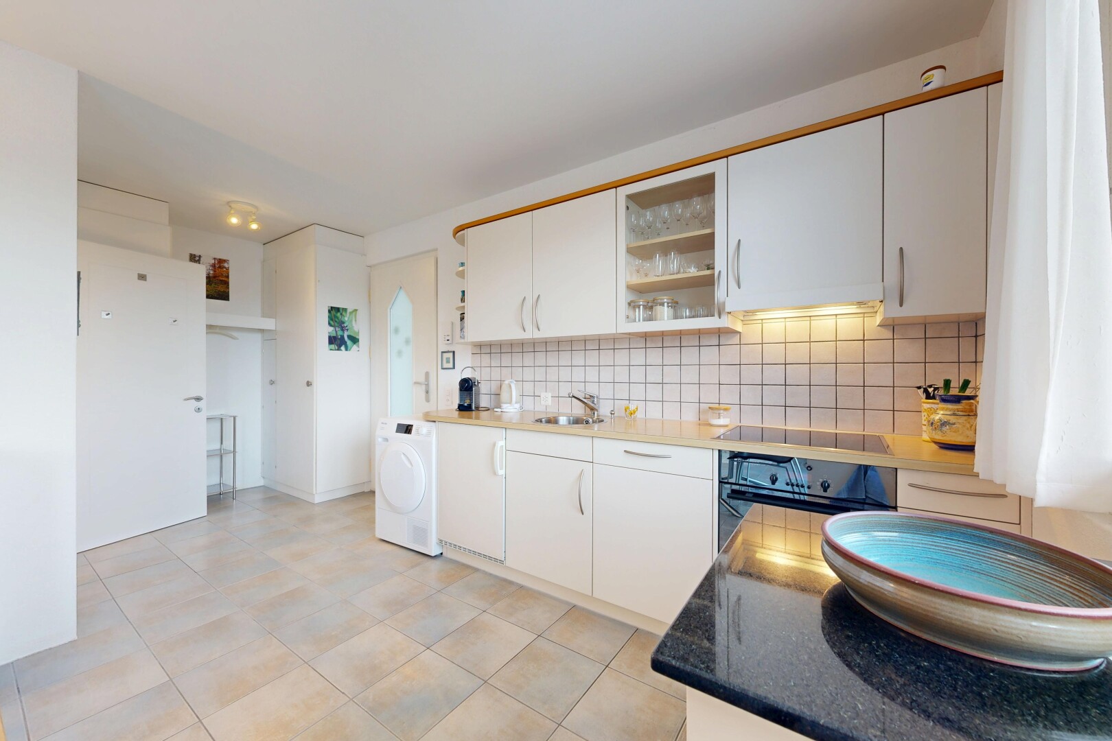 cuisine avec armoires blanches, lave-linge et sèche-linge, four, inside property, et dosseret