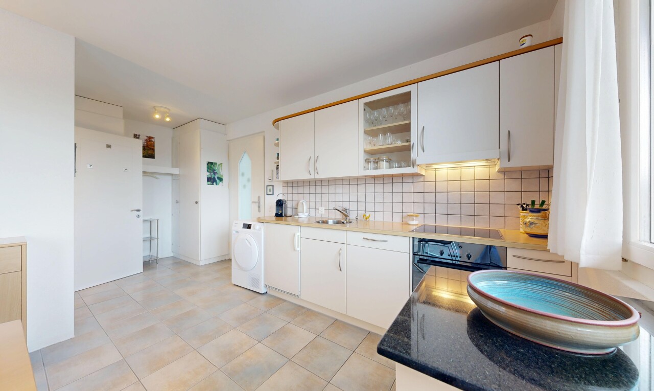 cuisine avec armoires blanches, lave-linge et sèche-linge, four, inside property, et dosseret
