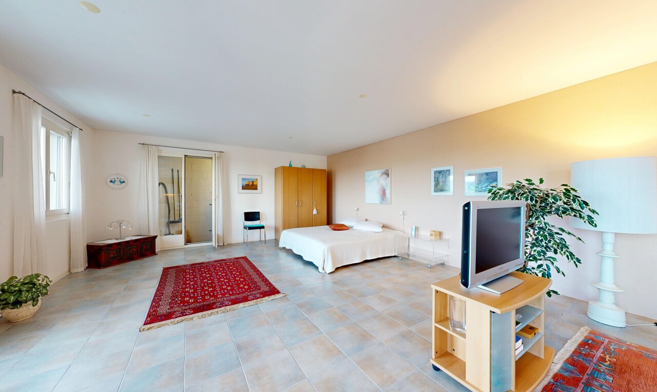 chambre avec télévision, cloison sèche, drywall, inside property, et lumière naturelle