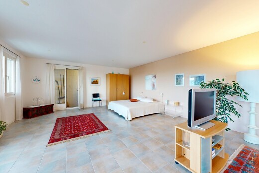 zimmer / schlafzimmer mit fernseher, gipskartonwand, drywall, inside property, und natürliches licht