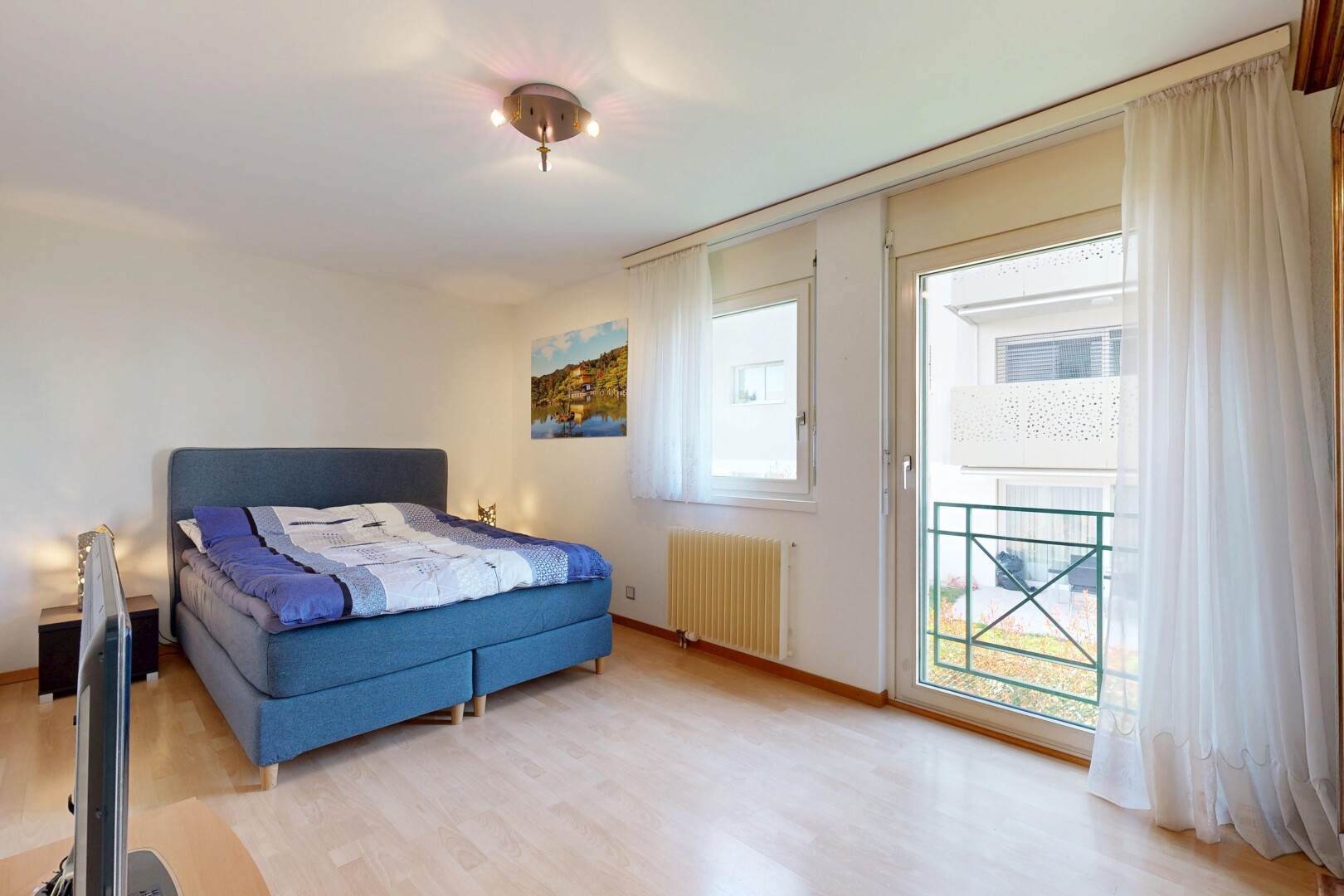 chambre avec drywall, cloison sèche, wood finish floor, sol en finition bois, et natural light