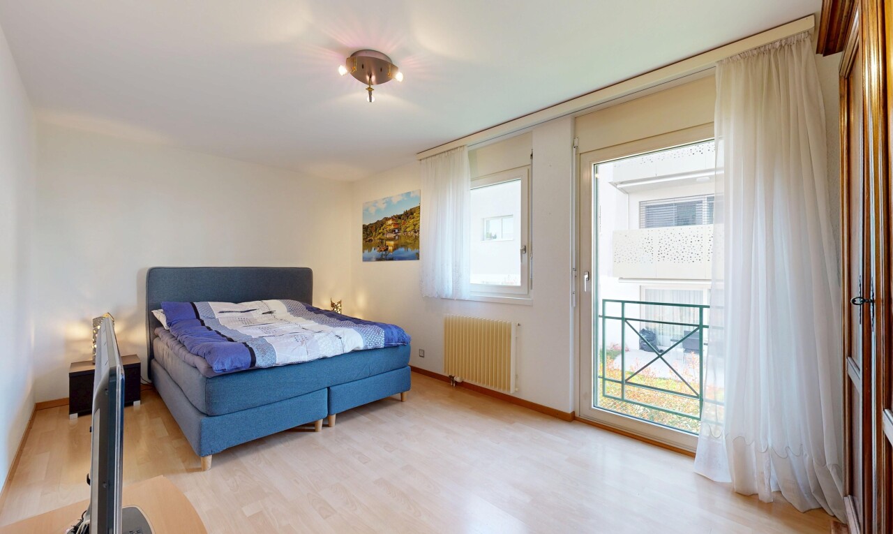 chambre avec drywall, cloison sèche, wood finish floor, sol en finition bois, et natural light
