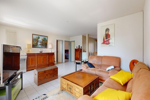 salon avec télévision, cloison sèche, drywall, inside property, et sol en carrelage