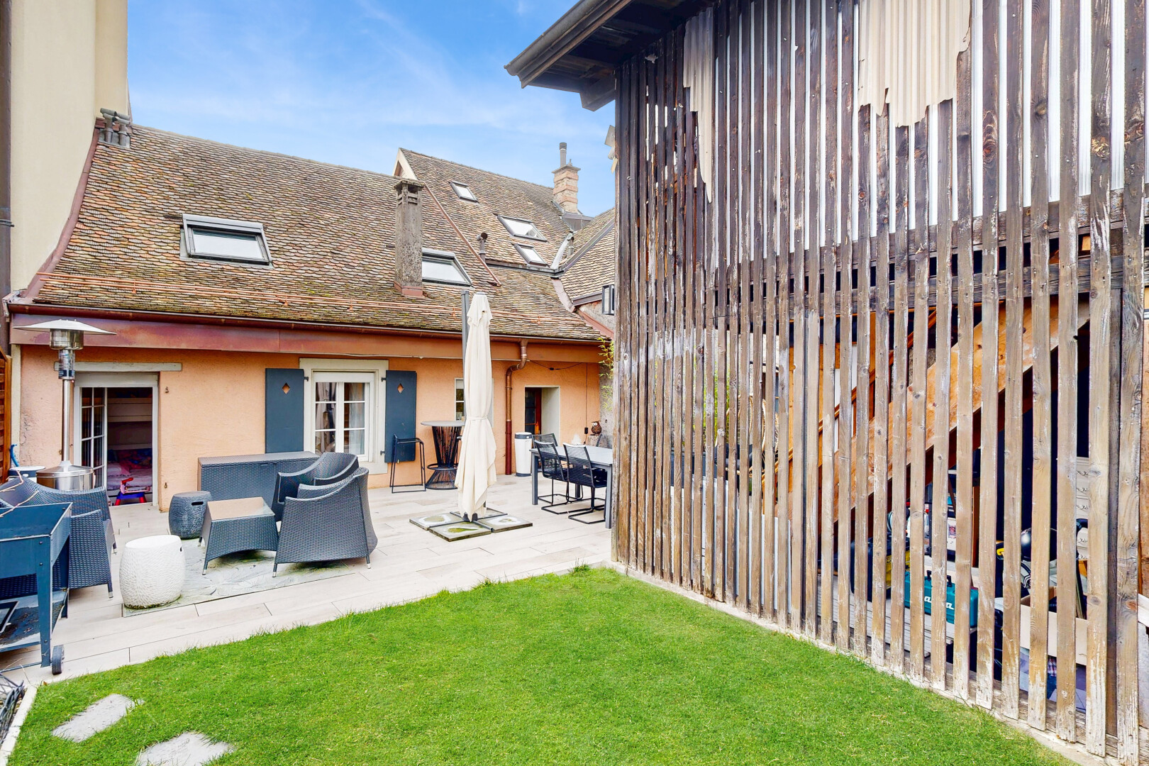 façade avec property visible, day time, terrasse, bardage en stuc, et pelouse