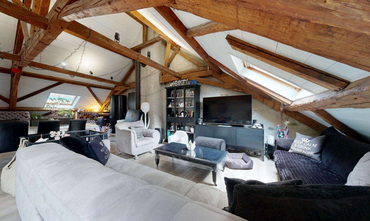 salon avec beamed ceiling, plafond à poutres, télévision, inside property, et vaulted ceiling