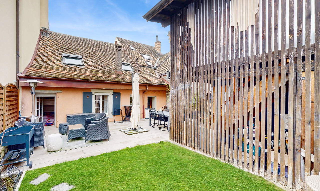 façade avec property visible, day time, terrasse, bardage en stuc, et pelouse