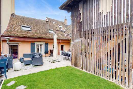 façade avec property visible, day time, terrasse, bardage en stuc, et pelouse