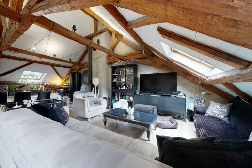 salon avec beamed ceiling, plafond à poutres, télévision, inside property, et vaulted ceiling