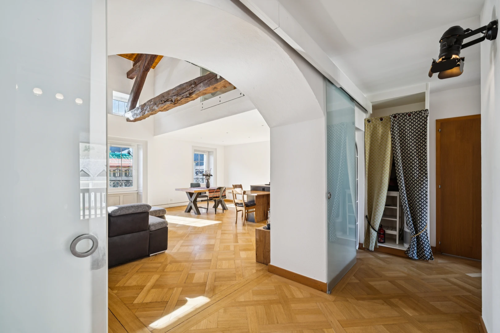 couloir avec passages en arc, drywall, cloison sèche, wood finish floor, et sol en finition bois