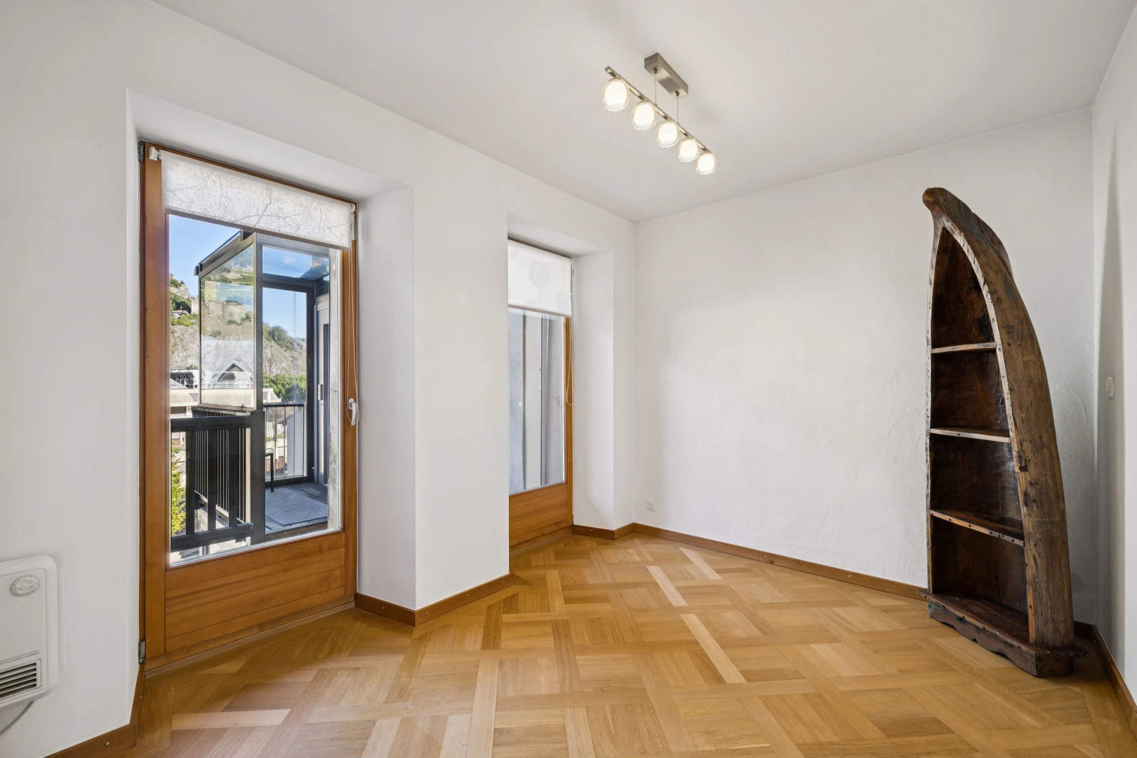 pièce vide avec éclairage sur rail, cloison sèche, drywall, accès à l'extérieur, et light floor
