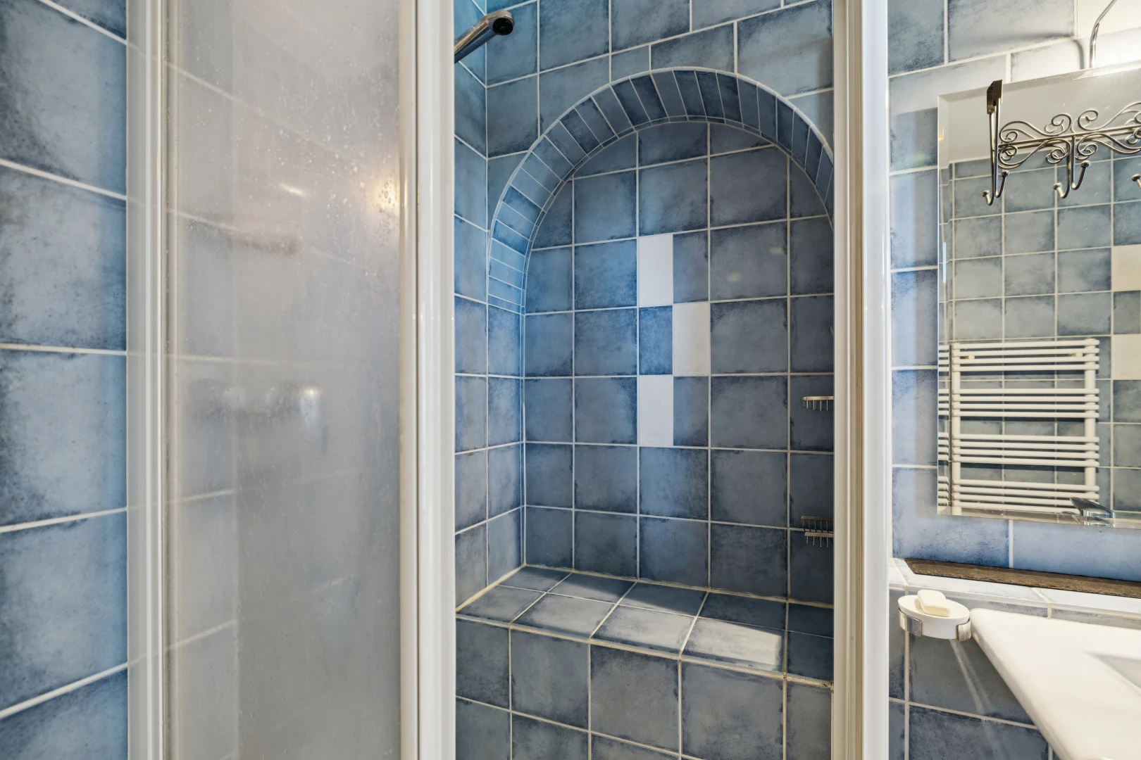 salle de bains avec douche, tile wall, mur en carrelage, chauffe-serviettes, et salle de bain complète