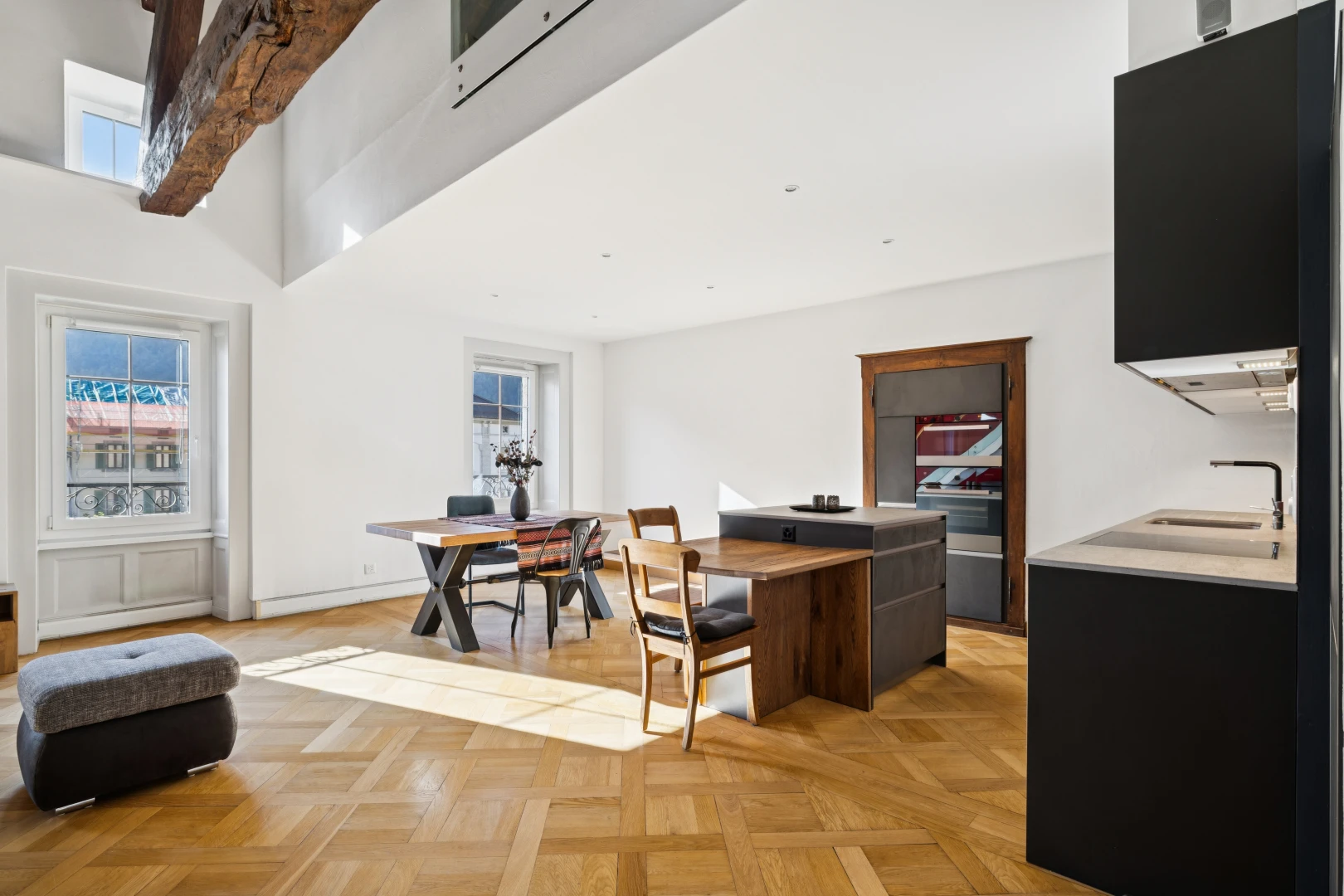 salon / salle à manger avec évier, light floor, drywall, cloison sèche, et wood finish floor