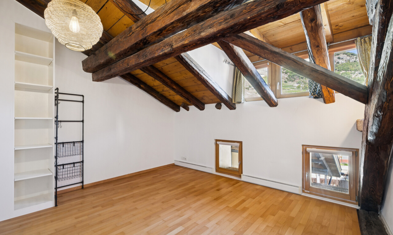pièce vide avec étagères intégrées, beamed ceiling, plafond à poutres, drywall, et cloison sèche