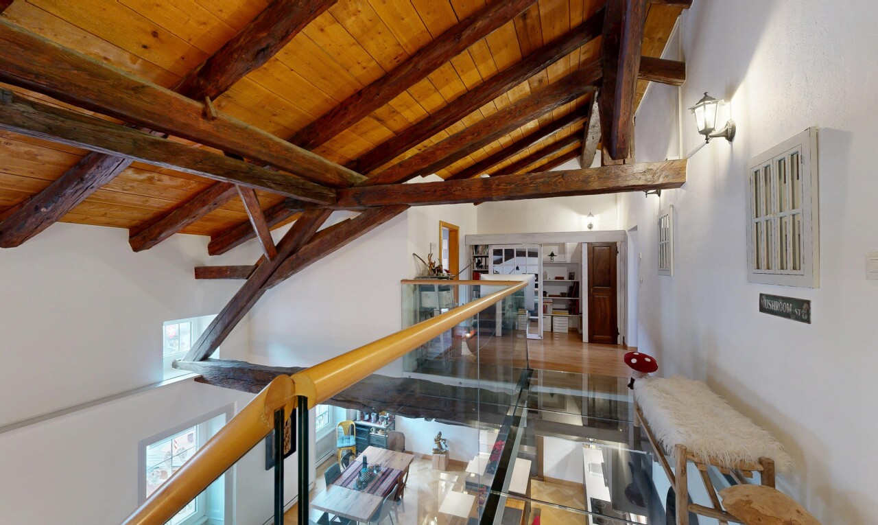 stairway with a wood ceiling with exposed beams and a high ceiling