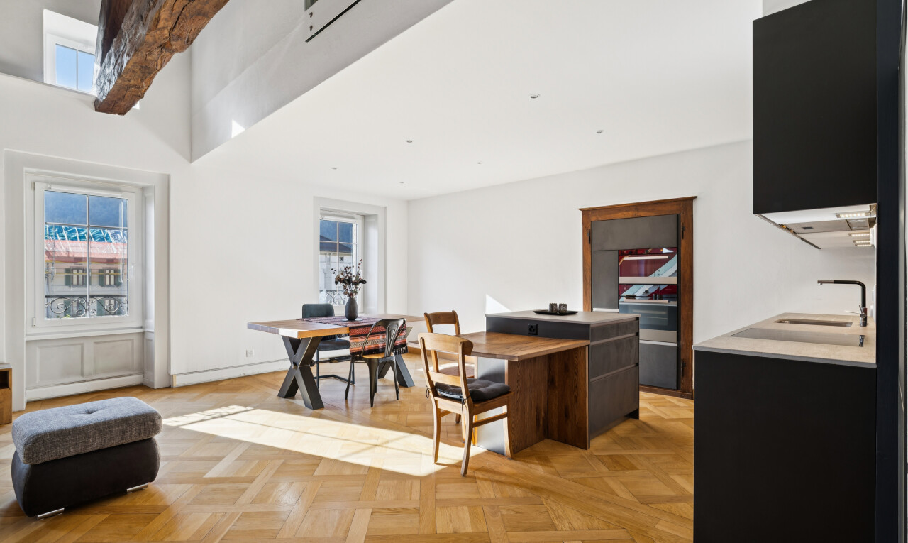 salon / salle à manger avec évier, light floor, drywall, cloison sèche, et wood finish floor