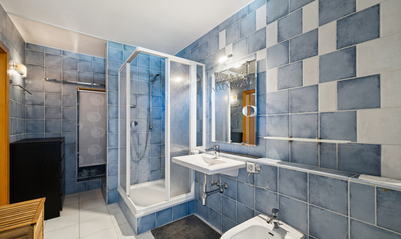 salle de bains avec tile wall, mur en carrelage, douche, salle de bain complète, et bidet