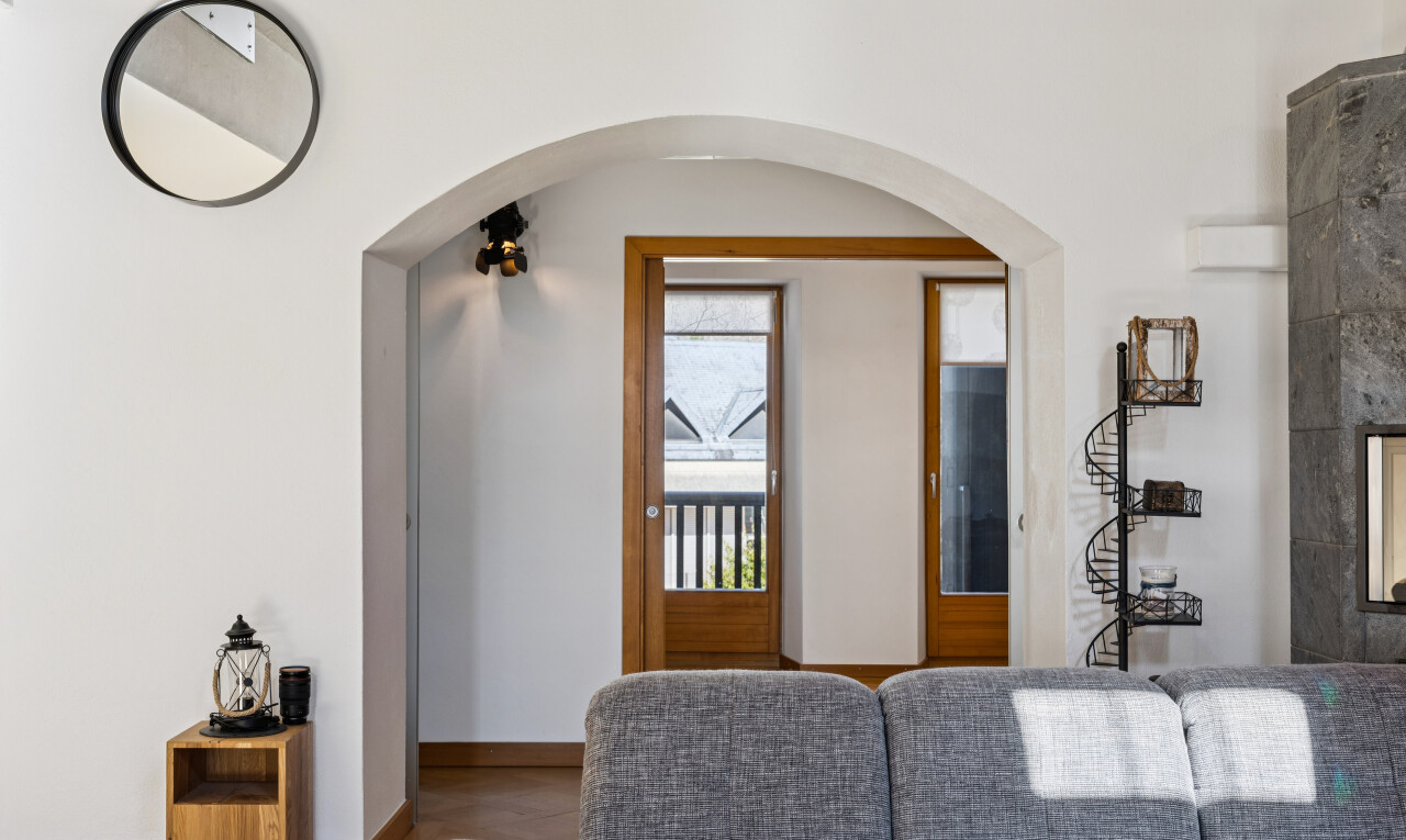salon avec accès à l'extérieur, drywall, cloison sèche, passages en arc, et baseboards wall