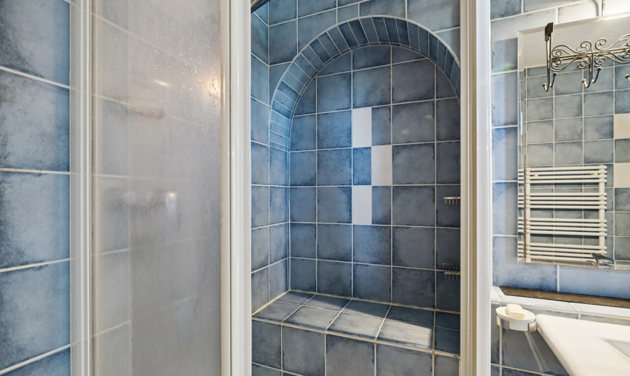 salle de bains avec douche, tile wall, mur en carrelage, chauffe-serviettes, et salle de bain complète