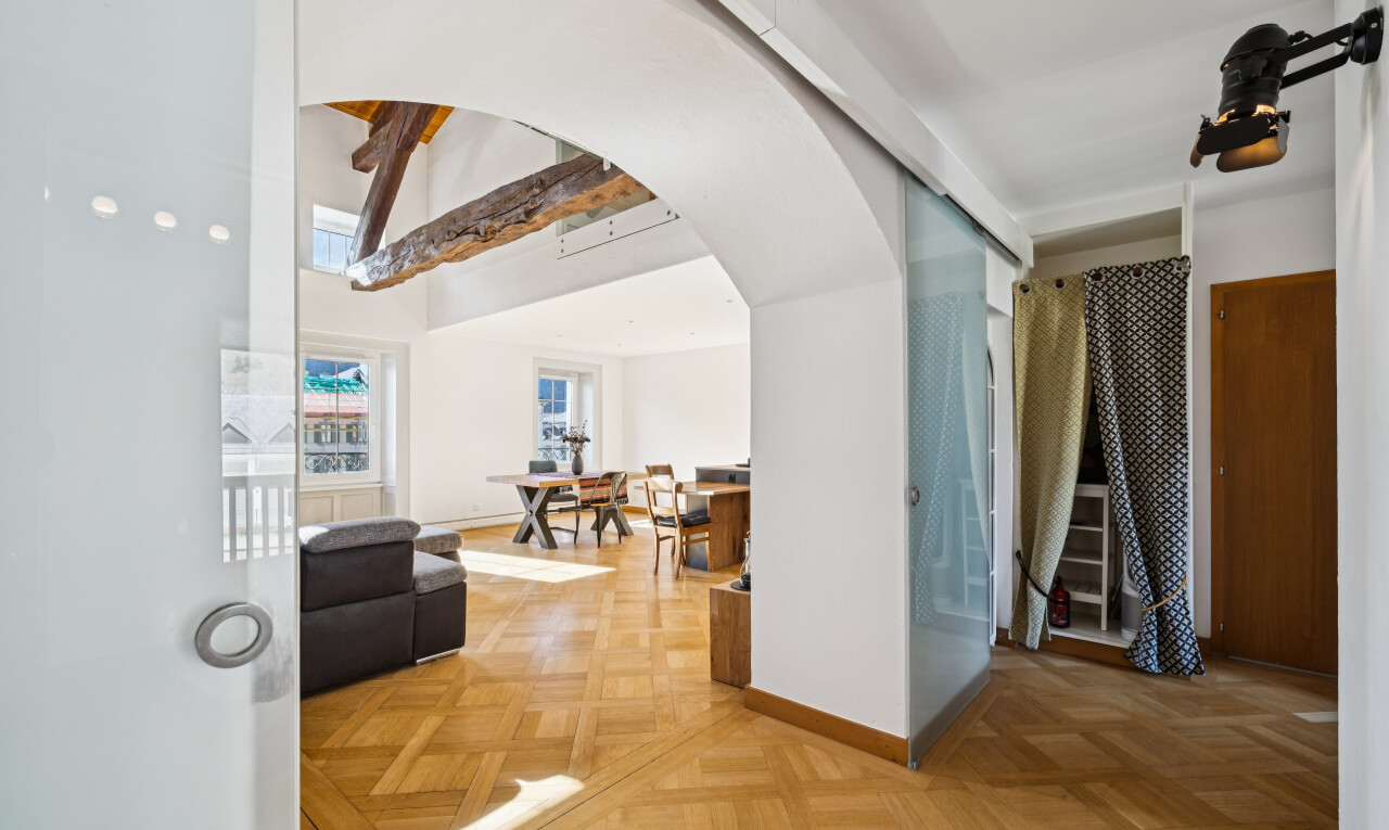 couloir avec passages en arc, drywall, cloison sèche, wood finish floor, et sol en finition bois