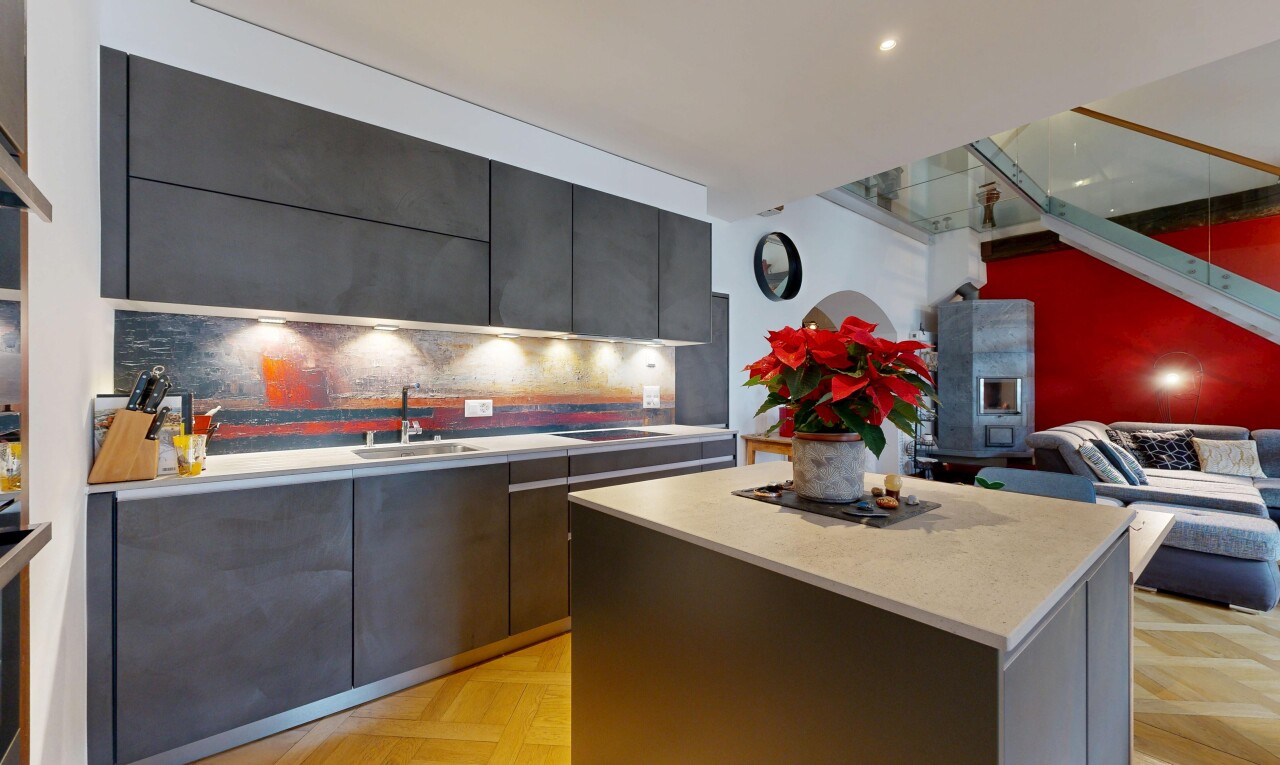 kitchen with modern cabinets, light countertops, a kitchen island, open floor plan, and tasteful backsplash