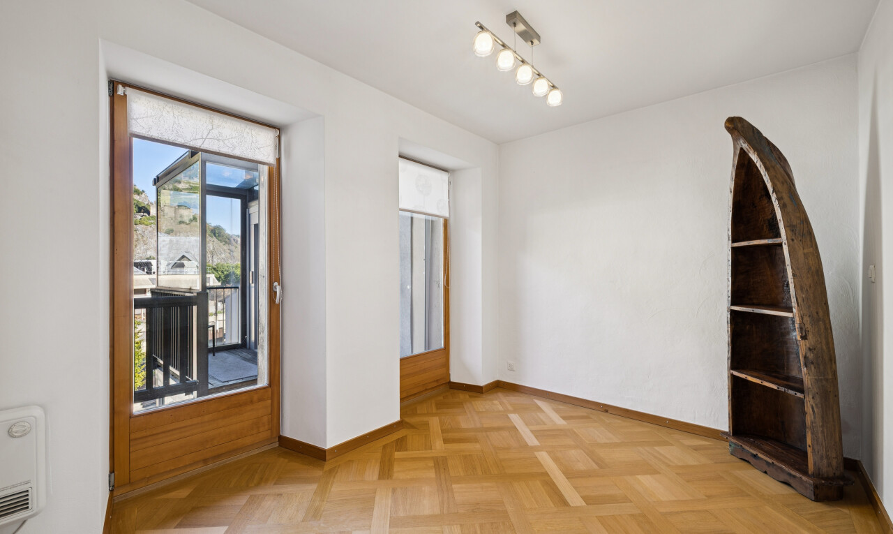 pièce vide avec éclairage sur rail, cloison sèche, drywall, accès à l'extérieur, et light floor