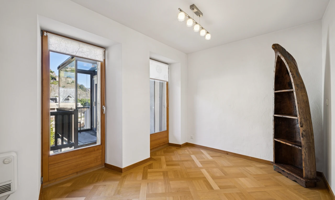 pièce vide avec éclairage sur rail, cloison sèche, drywall, accès à l'extérieur, et light floor