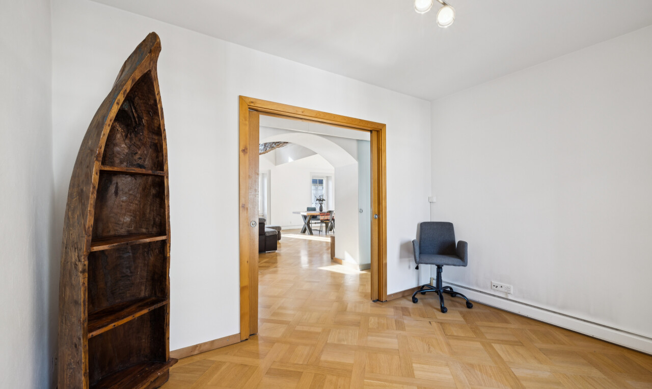 couloir avec éclairage sur rail, drywall, cloison sèche, passages en arc, et light floor