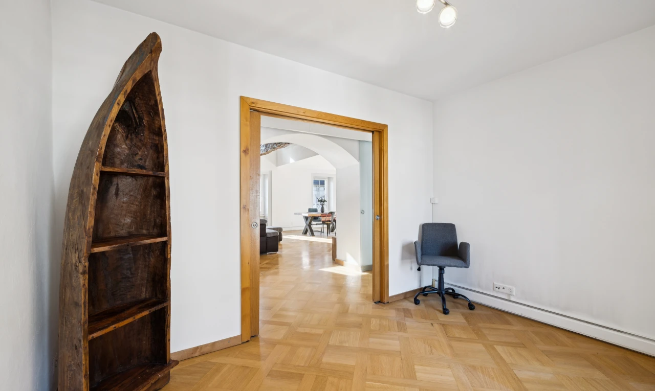 couloir avec éclairage sur rail, drywall, cloison sèche, passages en arc, et light floor